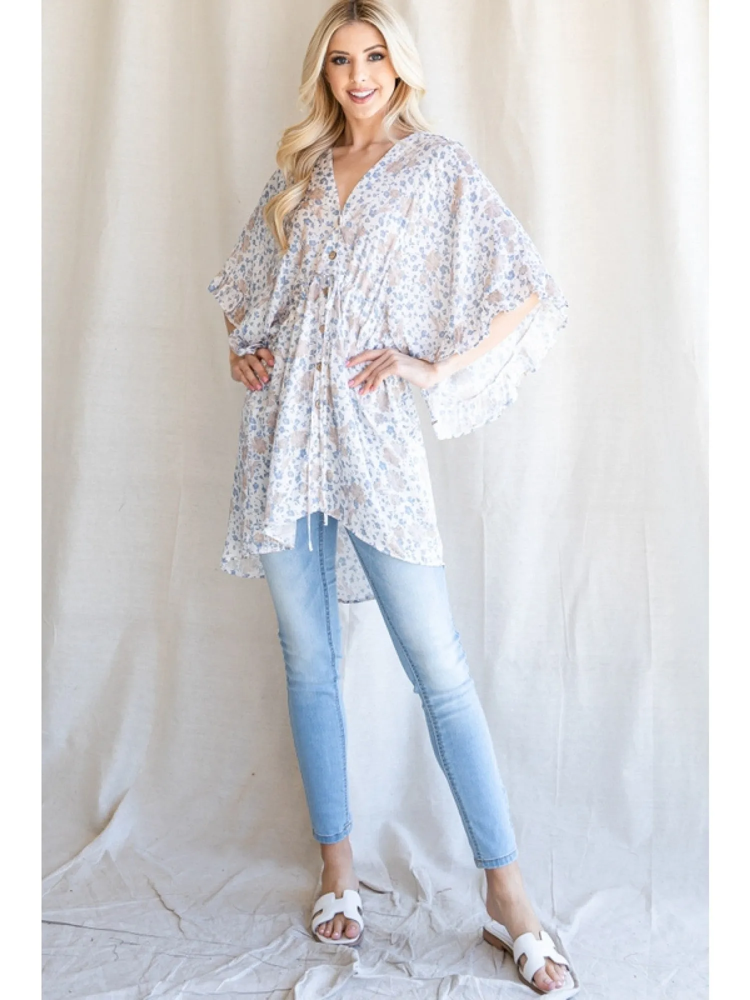 Satin floral print button up tunic with a V-neckline, drawstring waistline, and ruffle trim kimono half sleeve