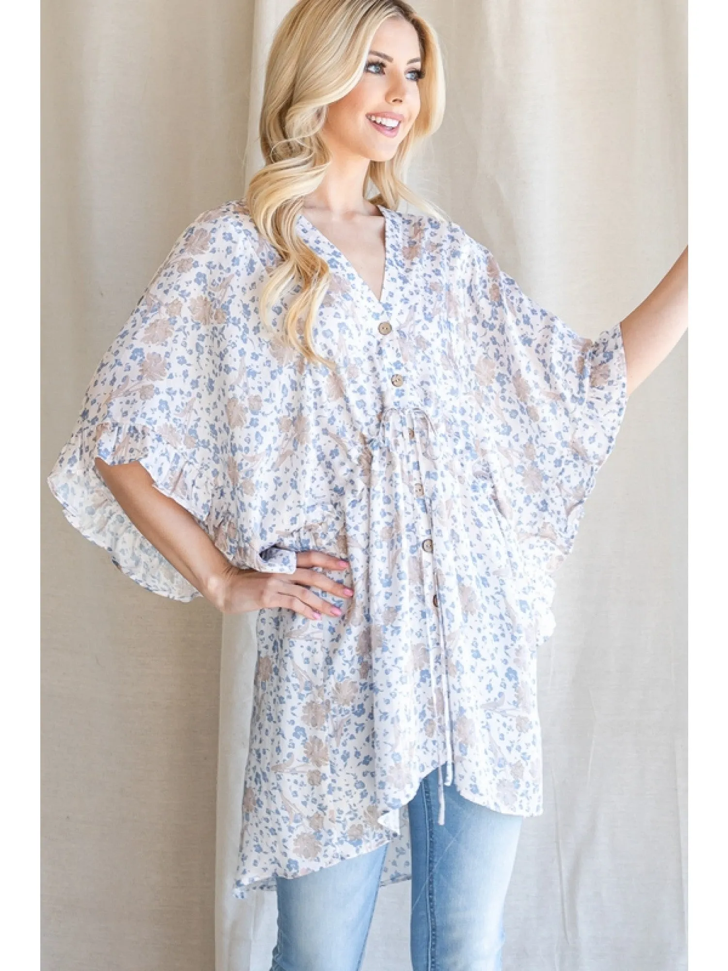 Satin floral print button up tunic with a V-neckline, drawstring waistline, and ruffle trim kimono half sleeve