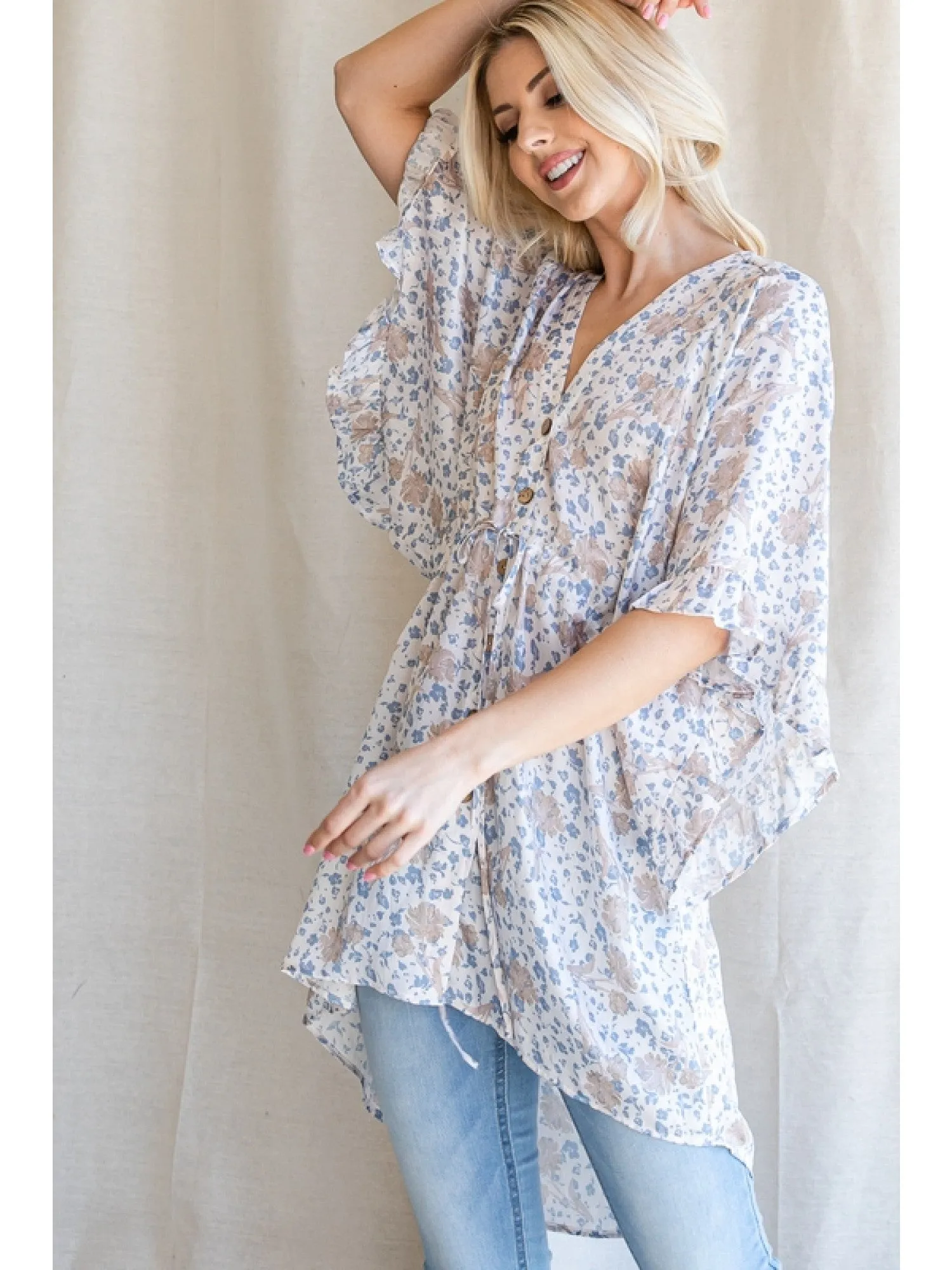 Satin floral print button up tunic with a V-neckline, drawstring waistline, and ruffle trim kimono half sleeve