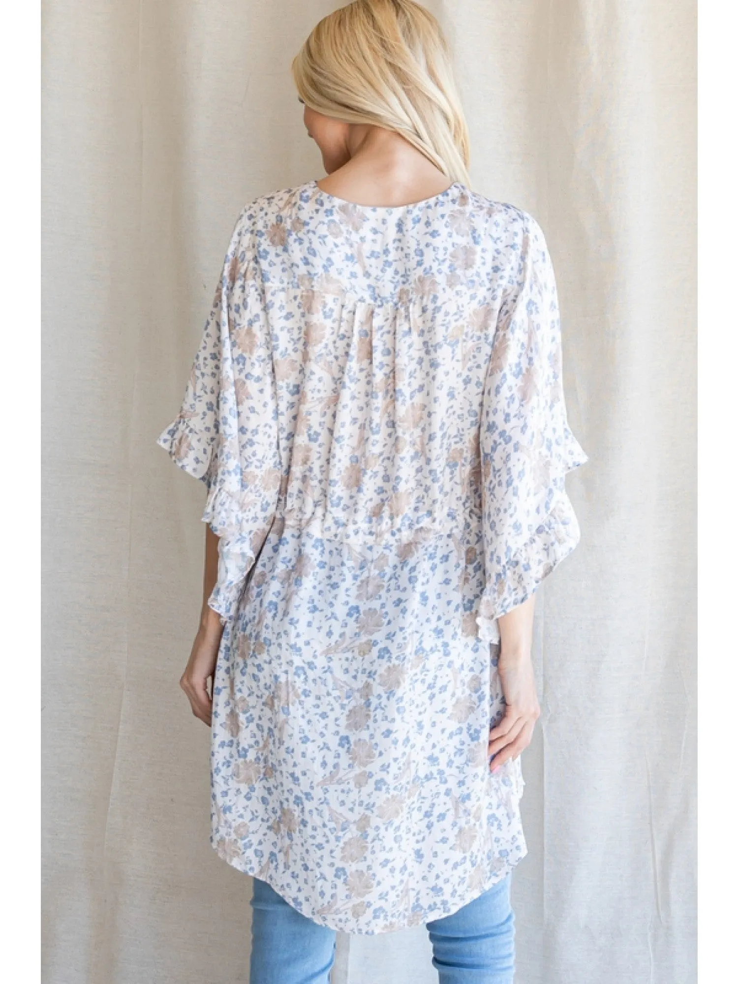 Satin floral print button up tunic with a V-neckline, drawstring waistline, and ruffle trim kimono half sleeve